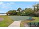 Outdoor basketball court with green surface and net, surrounded by trees and green grass near the lake at 920 Cool Springs Cir, Ocoee, FL 34761