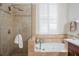 Elegant bathroom featuring a soaking tub with decorative tile surround and separate shower at 920 Cool Springs Cir, Ocoee, FL 34761