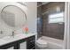Modern bathroom featuring gray tile in shower, black vanity, and round mirror at 920 Cool Springs Cir, Ocoee, FL 34761