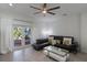 A stylish living room with sleek furniture, an outdoor view through glass doors, and a modern ceiling fan at 920 Cool Springs Cir, Ocoee, FL 34761