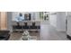Open-concept living room showcasing the kitchen, white walls, sleek floors, and an abundance of natural light at 920 Cool Springs Cir, Ocoee, FL 34761