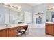 Bright bathroom featuring dual sinks, garden tub, glass block window and vanity space at 9521 Southern Garden Cir, Altamonte Springs, FL 32714