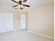 Well-lit bedroom featuring neutral carpet, ceiling fan, closet and door at 9521 Southern Garden Cir, Altamonte Springs, FL 32714