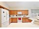 Well-lit kitchen with oak cabinets, white appliances, a microwave, and ample counter space at 9521 Southern Garden Cir, Altamonte Springs, FL 32714