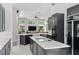Modern kitchen featuring dark cabinets, a large island, stainless steel appliances, and views of the backyard at 960 Brightwater Cir, Maitland, FL 32751