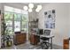 Bright home office with modern globe lighting, custom built-ins, and large window offering outdoor views at 960 Brightwater Cir, Maitland, FL 32751