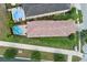 Aerial shot of a private pool and the property's backyard, surrounded by lush greenery and a red tile roof at 970 Golden Bear Dr, Reunion, FL 34747
