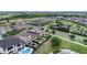Aerial view featuring residential area, backyard pools, and scenic community lake at 970 Golden Bear Dr, Reunion, FL 34747