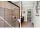 Bright bathroom featuring tiled shower with glass door, vanity, and neutral decor at 970 Golden Bear Dr, Reunion, FL 34747