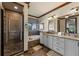 A bathtub sits next to a glass-enclosed shower with double vanity and dark wood trim in this bathroom at 970 Golden Bear Dr, Reunion, FL 34747