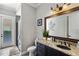 Well-lit bathroom with granite countertop, dark vanity, and glass-enclosed shower at 970 Golden Bear Dr, Reunion, FL 34747