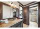 A vanity with granite countertops complements the adjacent shower and doorway to the bedroom in this bathroom at 970 Golden Bear Dr, Reunion, FL 34747