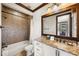 Well-lit bathroom featuring granite countertops, white cabinets, and a shower-tub combo at 970 Golden Bear Dr, Reunion, FL 34747