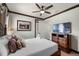 Well-lit bedroom featuring a decorative metal bed frame, side tables, dark wood trim and a ceiling fan at 970 Golden Bear Dr, Reunion, FL 34747
