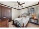 Comfortable bedroom featuring a decorative metal bed frame, side tables, dark wood trim and a ceiling fan at 970 Golden Bear Dr, Reunion, FL 34747