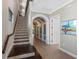 Elegant entryway with tile flooring, staircase with wooden handrail, and arched doorway leading to hallway at 970 Golden Bear Dr, Reunion, FL 34747