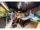 A cool game room has a pool table, arcade games, and chairs set against a mural wall at 970 Golden Bear Dr, Reunion, FL 34747