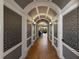 Elegant hallway features decorative wall panels, a beautiful archway, and tile flooring at 970 Golden Bear Dr, Reunion, FL 34747