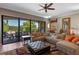 Comfortable living room with large sectional sofa, ceiling fan, and sliding doors to outdoor patio at 970 Golden Bear Dr, Reunion, FL 34747