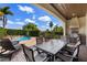 Outdoor dining space with built-in grill and view of the private pool and manicured backyard landscaping at 970 Golden Bear Dr, Reunion, FL 34747