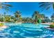Large resort pool surrounded by palm trees and lounge chairs, perfect for relaxation and recreation at 970 Golden Bear Dr, Reunion, FL 34747
