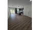 Spacious living area with wood flooring flows into kitchen with modern island and stainless appliances at 1005 Randall St, Orlando, FL 32805