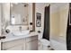 This bathroom features a modern sink, toilet, and shower/bath, complete with a decorative mirror and framed wall art at 10293 Cypress Knee Cir, Orlando, FL 32825