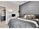 Spacious bedroom featuring a gray accent wall, plush comforter, and an ensuite bathroom for added convenience at 10293 Cypress Knee Cir, Orlando, FL 32825