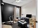 Versatile bedroom space with a black accent wall, treadmill, telescope, and entertainment setup at 10293 Cypress Knee Cir, Orlando, FL 32825