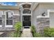 Stylish front entrance features a black door, transom window, and stone accents at 10293 Cypress Knee Cir, Orlando, FL 32825