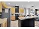 Open kitchen with light wood cabinets, black appliances, and a breakfast bar at 10293 Cypress Knee Cir, Orlando, FL 32825