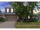Charming two-story home with a two car garage, manicured lawn, and mature trees at 10337 Cypress Trail Dr, Orlando, FL 32825