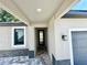 Inviting entryway with stylish tile flooring, a modern light fixture, and direct access to the garage at 107 Grove St, Orlando, FL 32835