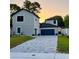 Beautiful home with a paved driveway, modern architecture, and a lovely sunset backdrop at 107 Grove St, Orlando, FL 32835
