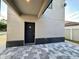 Modern home entrance with stone accents, gray brick pavers, and well-designed curb appeal at 107 Grove St, Orlando, FL 32835