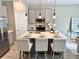 Kitchen island with seating, stylish lighting, stainless appliances, and neutral decor at 107 Grove St, Orlando, FL 32835