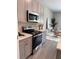Bright kitchen boasts stainless steel appliances and neutral decor at 107 Grove St, Orlando, FL 32835