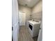 Functional laundry room with modern machines, tile flooring, and storage shelves at 107 Grove St, Orlando, FL 32835