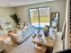Stylish living area with a cozy sofa, large windows overlooking the yard, and a dining table set for entertaining at 107 Grove St, Orlando, FL 32835