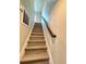 Stairway with modern wooden steps and a sleek black handrail for an elegant transition between floors at 107 Grove St, Orlando, FL 32835