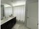 Bright bathroom featuring double vanity with dark cabinets, a large mirror, and shower at 1078 Splash Shot Pl, Davenport, FL 33896