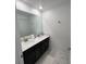 Bathroom featuring dual sinks, black cabinetry, and white countertops at 1078 Splash Shot Pl, Davenport, FL 33896