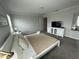 Nicely staged bedroom with bed and television on a stylish, white cabinet at 1078 Splash Shot Pl, Davenport, FL 33896
