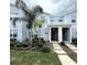 Stylish townhome with a modern exterior, landscaped front yard, and a striking red front door at 1078 Splash Shot Pl, Davenport, FL 33896