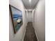 Hallway with gray carpeting and beach-themed painting on wall at 1078 Splash Shot Pl, Davenport, FL 33896