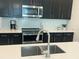 Modern kitchen with stainless steel appliances, dark cabinets, and white quartz countertops at 1078 Splash Shot Pl, Davenport, FL 33896