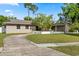 A view of the front exterior of the property, highlighting its well-maintained lawn and ample parking at 110 S Edgemon Ave, Winter Springs, FL 32708