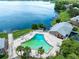 Aerial view of a community pool near a lake with lounge chairs and palm trees, offering a relaxing outdoor space at 117 Georgetown Dr # C, Casselberry, FL 32707