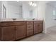 Bathroom featuring dual vanity sinks with granite countertops and wood-look tiled floors at 12009 Walmsley Aly, Winter Garden, FL 34787