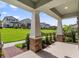 Inviting covered porch view showcasing the neighborhood's green space and manicured lawns at 12009 Walmsley Aly, Winter Garden, FL 34787